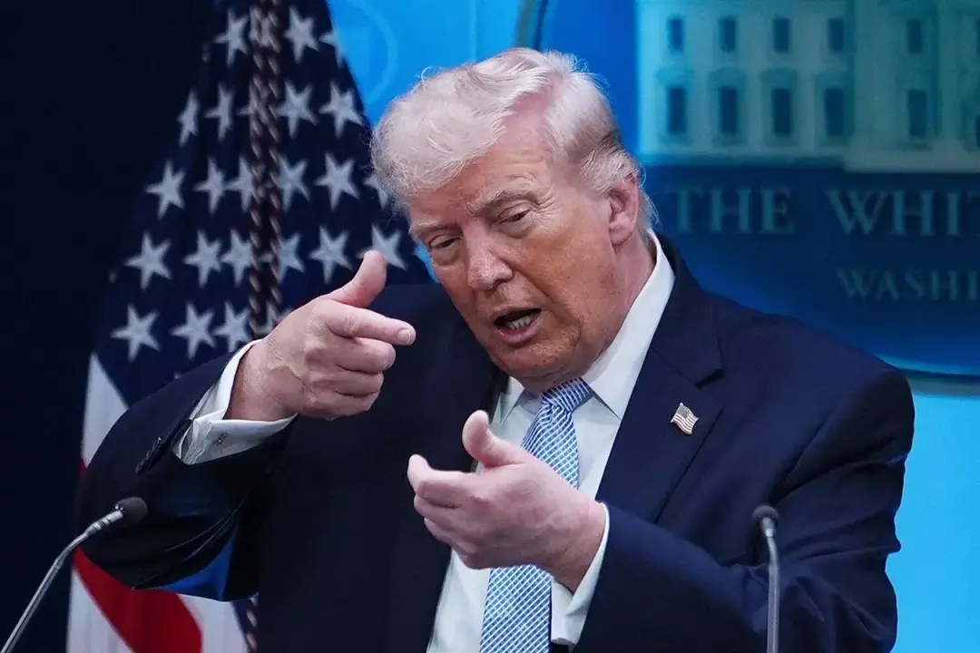 U.S. President Donald Trump gestures as if aiming a sniper rifle while speaking with reporters at the White House on April 6, 2026. Photo: AP